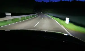 Nocna jazda po krętej drodze oświetlonej przez inteligentne światła matrycowe.