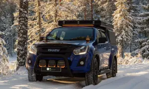 Niebieski Isuzu w zimowym lesie, z dodatkowymi światłami LED na dachu i zderzaku. Dowiedz się, jak ustawić żarówki LED w samochodzie, by podróżować bezpiecznie.