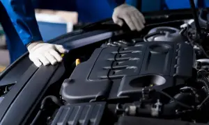 Mechanik w białych rękawiczkach sprawdza silnik Ecotec.