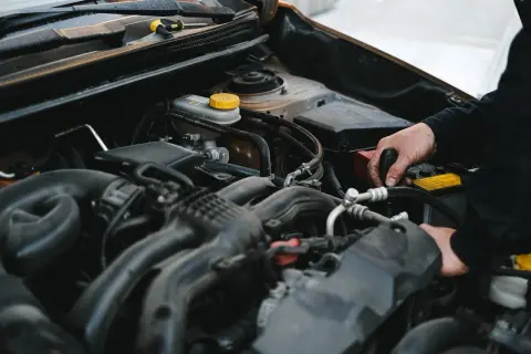 Mechanik pracuje przy silniku, sprawdzając, czy sucha miska olejowa jest szczelna.
