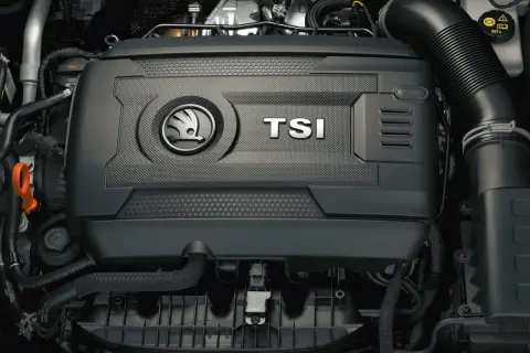 Silnik 1.8 TSI w samochodzie Skoda. Widoczna pokrywa silnika z logo marki i napisem TSI.