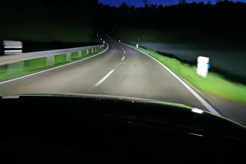 Nocna jazda po krętej drodze oświetlonej przez inteligentne światła matrycowe.