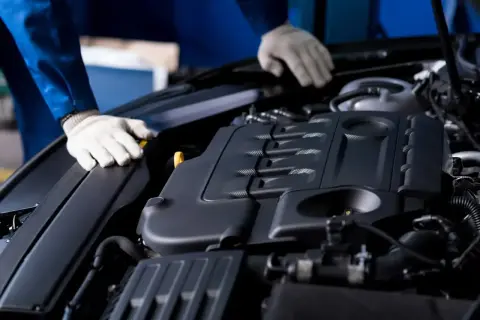 Mechanik w białych rękawiczkach sprawdza silnik Ecotec.