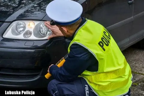 Policjant sprawdza reflektor, czy żarówki postojowe led są legalne. Lubuska Policja.