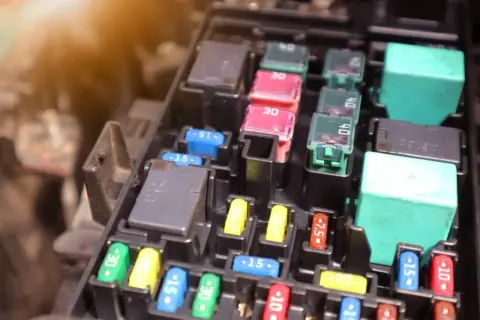 Skrzynka z bezpiecznikami i przekaźnikami, typowa dla Ford Focus MK2. Widać bezpieczniki o różnej wartości prądu.