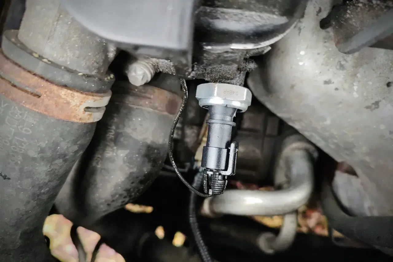 Czujnik ciśnienia oleju 1.9 TDI znajduje się w pobliżu metalowych rur i przewodów silnika.